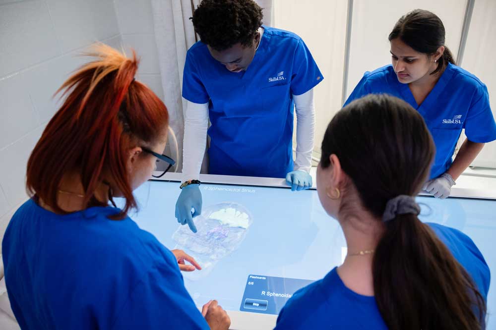 Four medical students looking at an interactive terminal